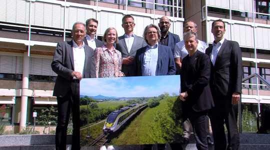 Die Projektbeteiligten halten vor dem Landratsamt ein Bild der Zollern-Alb-Bahn hoch | Bildquelle: RTF.1